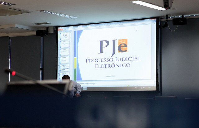 Foto de Curso do Processo Judicial Eletrônico realizado no CNJ em Brasília. Imagem mostra o ambiente do sistema PJe em auditório com projetor e tela grande