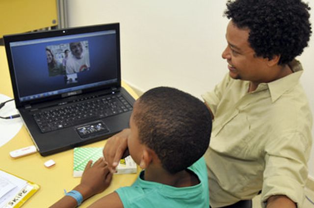 Imagem de teleconferência, via computador, entre criança e pretendentes à adoção