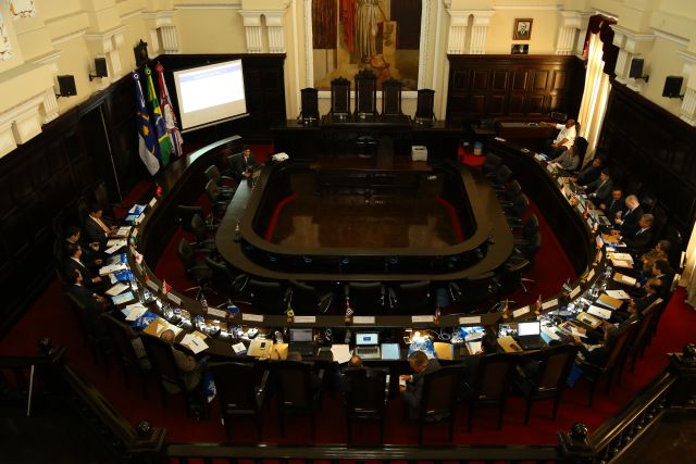 Vista superior do Salão do Pleno do TJPE com magistrados reunidos sentados em cadeiras no formato da letra U