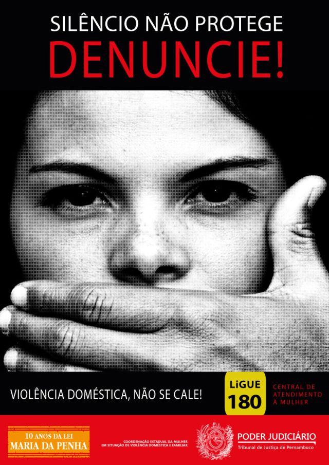 Cartaz, em fundo preto, onde se vê o rosto de uma mulher sendo impedida de falar. Frase: silêncio não protege. Denuncie.