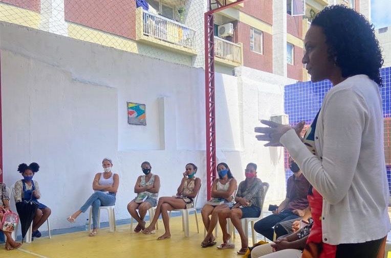 Mulher no primeiro plano em palestra sobre enfrentamento à violência doméstica 