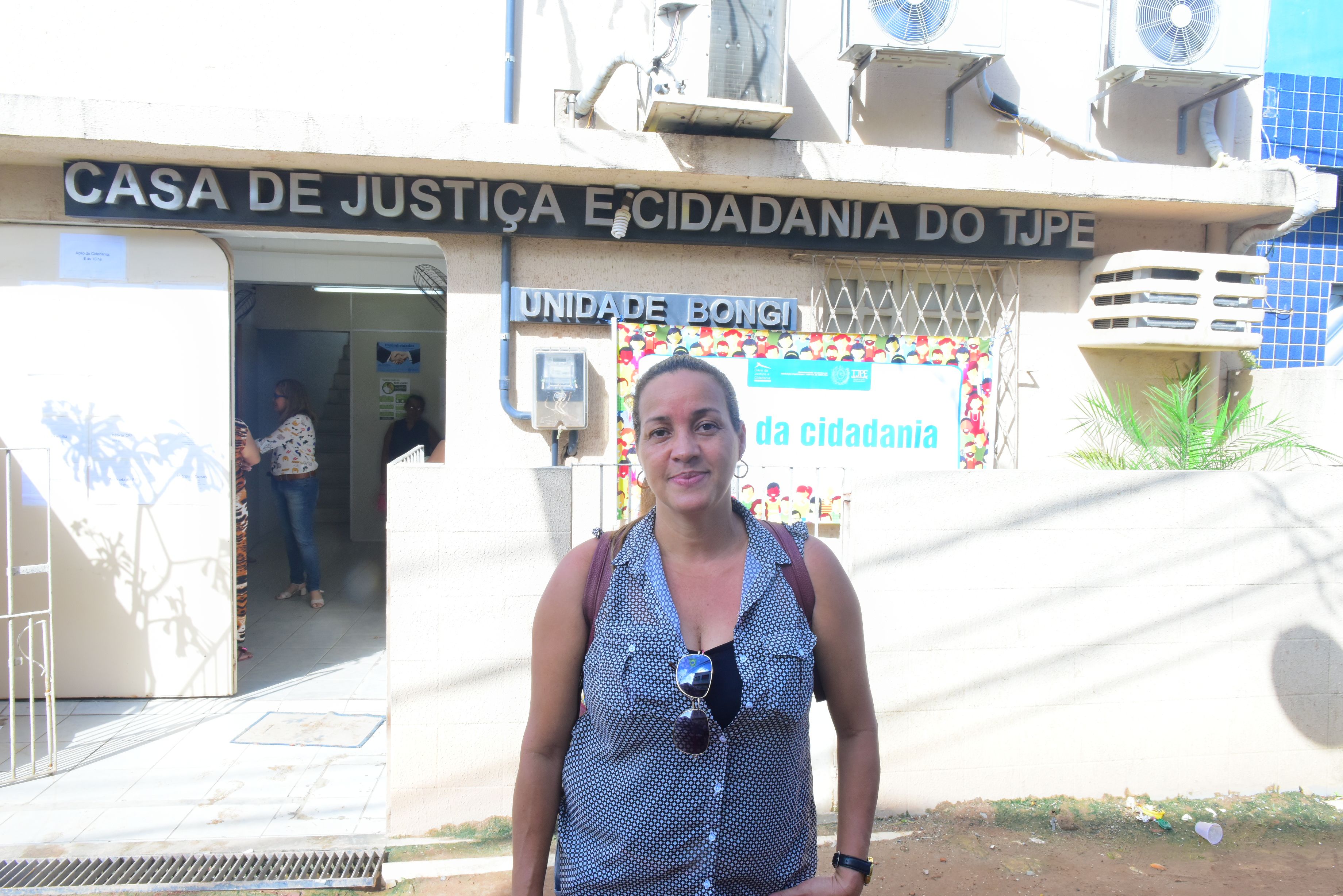 Mulher em frente à Casa de Justiça e Cidadania do Bongi