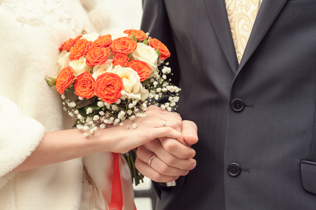 Casal com um buquê de flores durante cerimônia