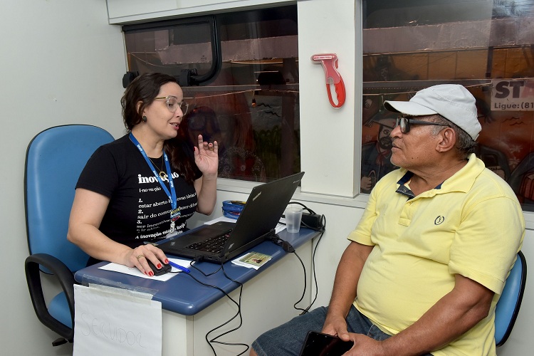 Um senhor sendo atendido por uma servidora durante o Justiça Itinerante 