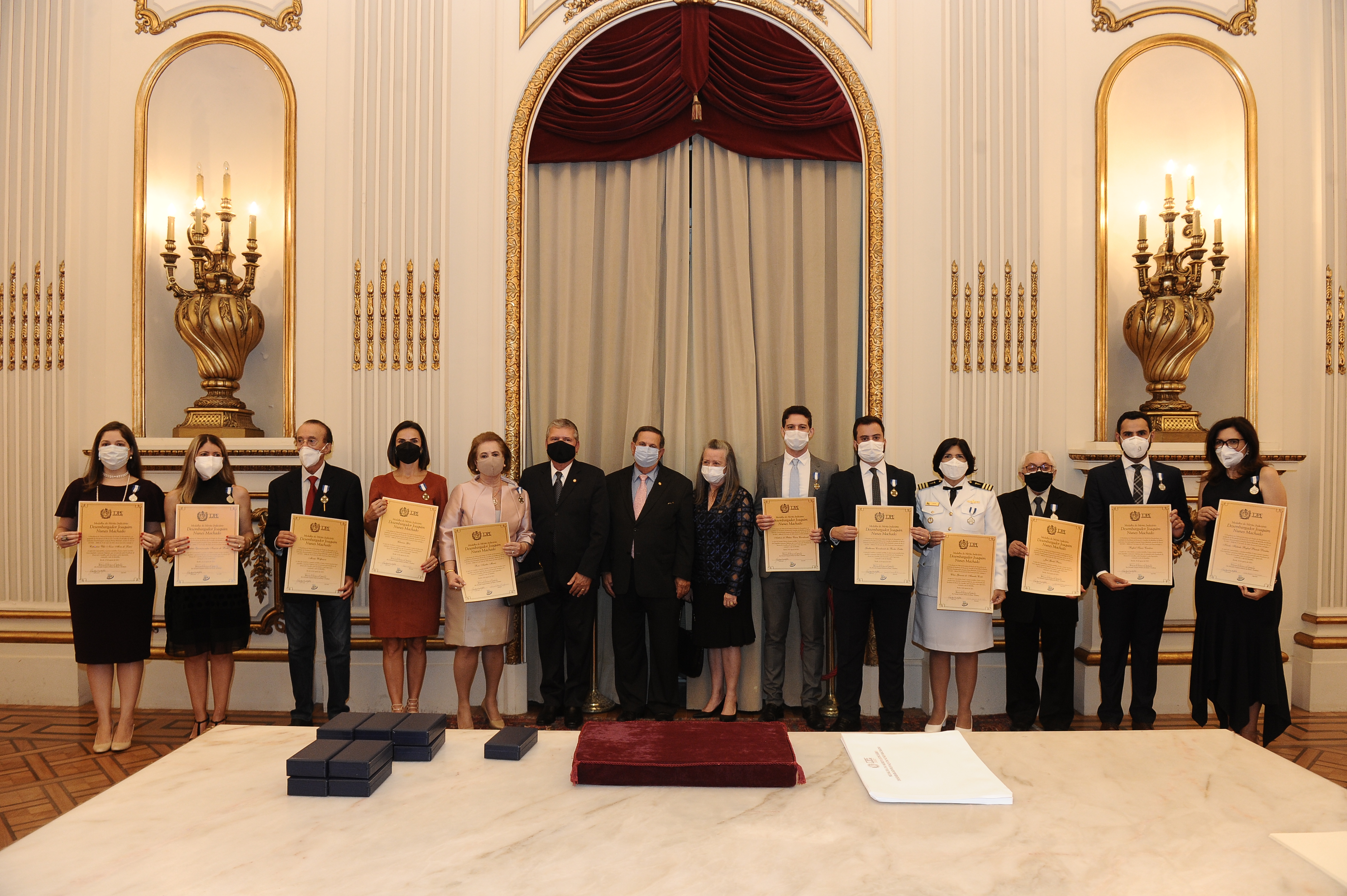 Homens e mulheres, lado a lado, segurando um diploma
