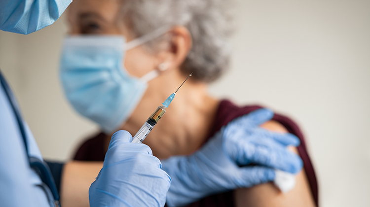 Imagem de uma senhora recebendo a vacina contra a covid-19