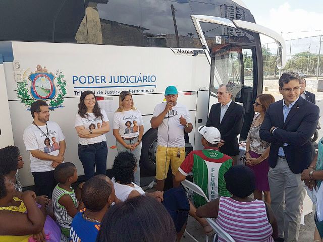 Moradores e representantes do Judiciário conversam ao lado do ônibus Justiça Itinerante