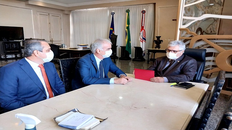 Três autoridades sentadas na mesa de reunião do gabinete da Presidência do TJPE