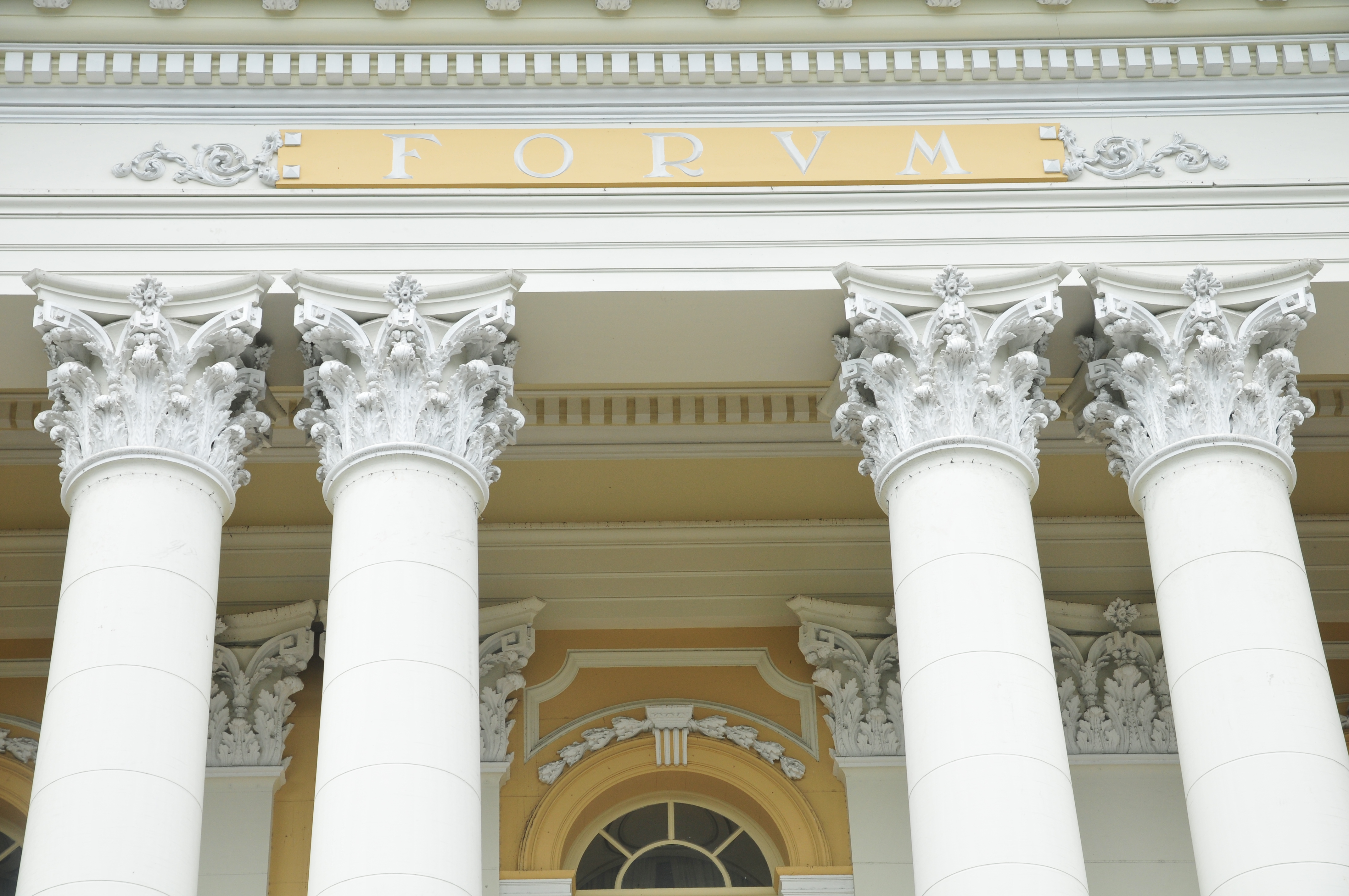 Detalhe da fachada do Palácio da Justiça onde se veem colunas com detalhes em amarelo e branco