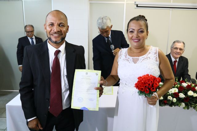 Casal faz foto oficial segurando certidão de casamento