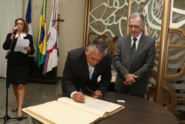 O presidente do TJPE Leopoldo Raposo observa Évio Marques assinar o termo de sua posse como desembargador
