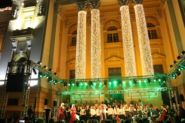 Palácio iluminado e coral cantando para público