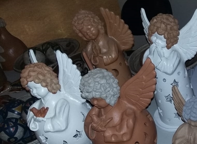A foto mostra esculturas de barro representando anjos