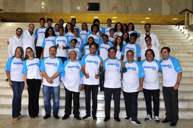 Estudantes e representantes das três instituições, TJPE, OCC e Cognitivo, na escadaria do Fórum do Recife, sorrindo para a foto, vestindo camisas brancas com detalhes azuis