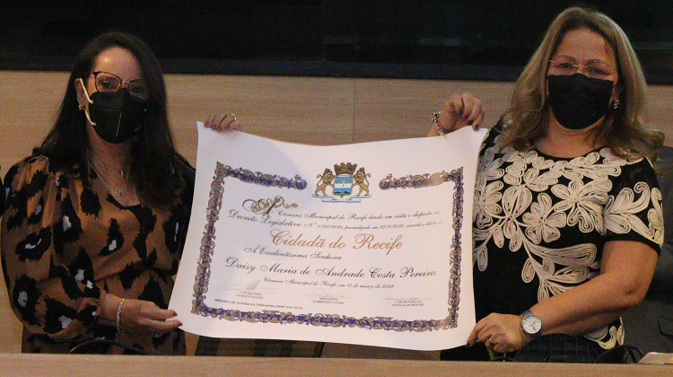 Desembargadora Daisy Andrade e vereadora Ana Lúcia, lado a lado, segurando diploma