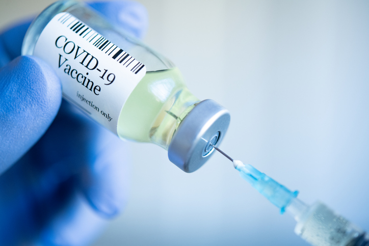 Foto de seringa retirando dose da vacina da Covid-19 de um frasco de vidro