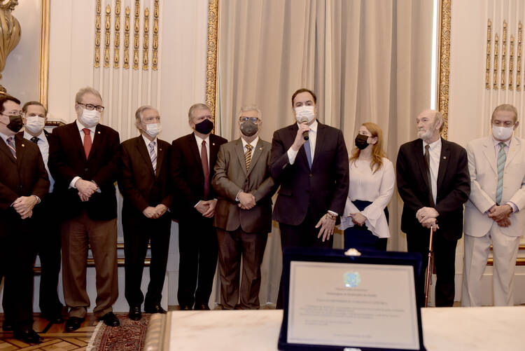 Foto do governador Paulo Câmara fazendo o discurso de agradecimento pela homenagem. O gestor está em pé segurando o microfone. Ele veste um paletó preto e usa máscara facial.