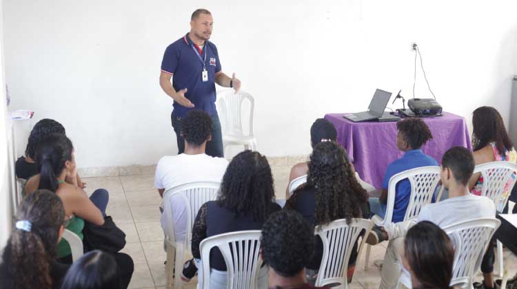 Foto do professor Anderson Muniz conversando com a plateia de adolescentes