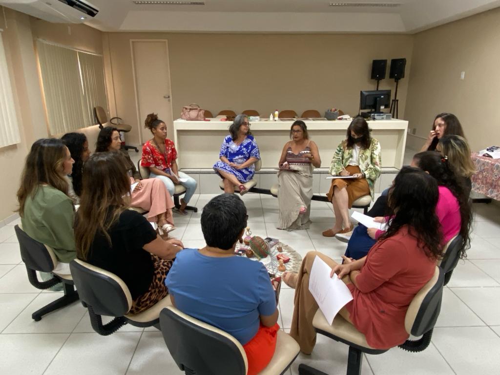 Foto mostra mulheres reunidas, sentadas em círculo