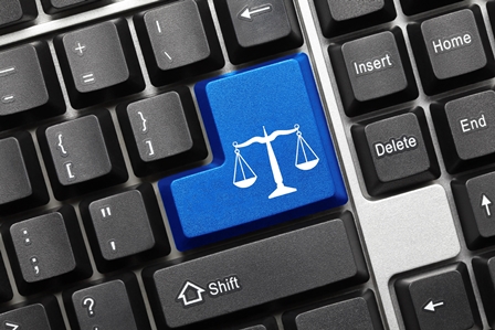 Imagem de uma balança, símbolo da Justiça, está desenhada no teclado de um computador para simbolizar a prestação jurisdicional online