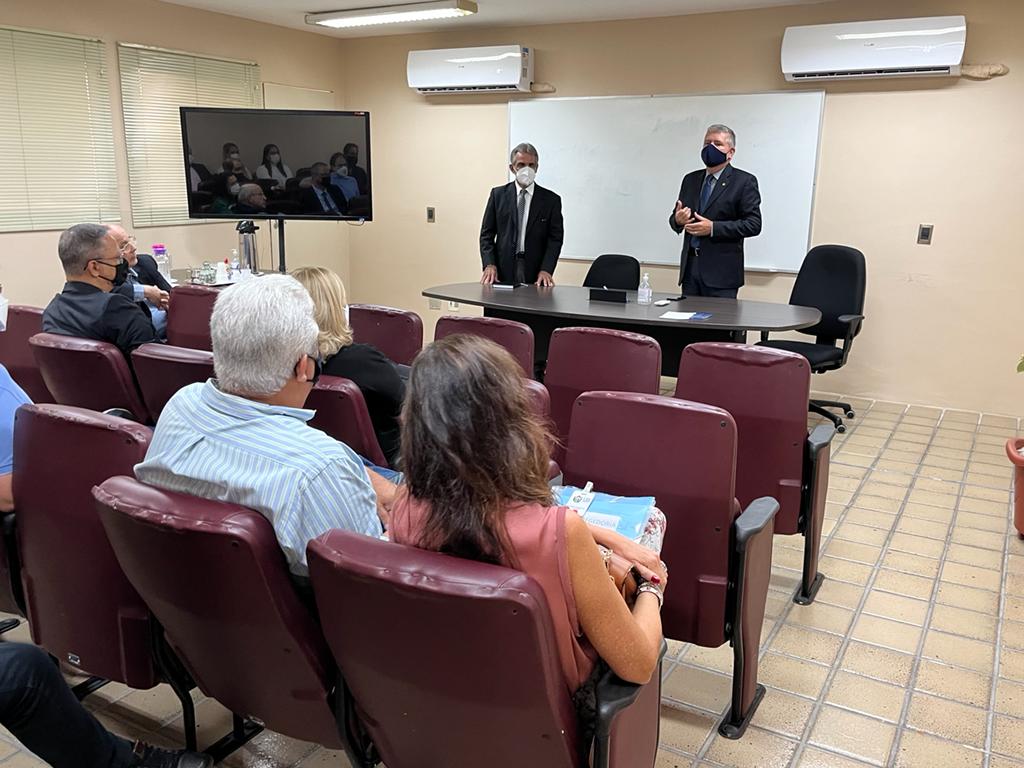 Dois homens em pé, o corregedor-geral e o juiz do extrajudicial, no auditório da Corregedoria falando para outras pessoas sentadas
