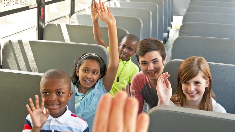 Crianças sentadas nos bancos do ônibus
