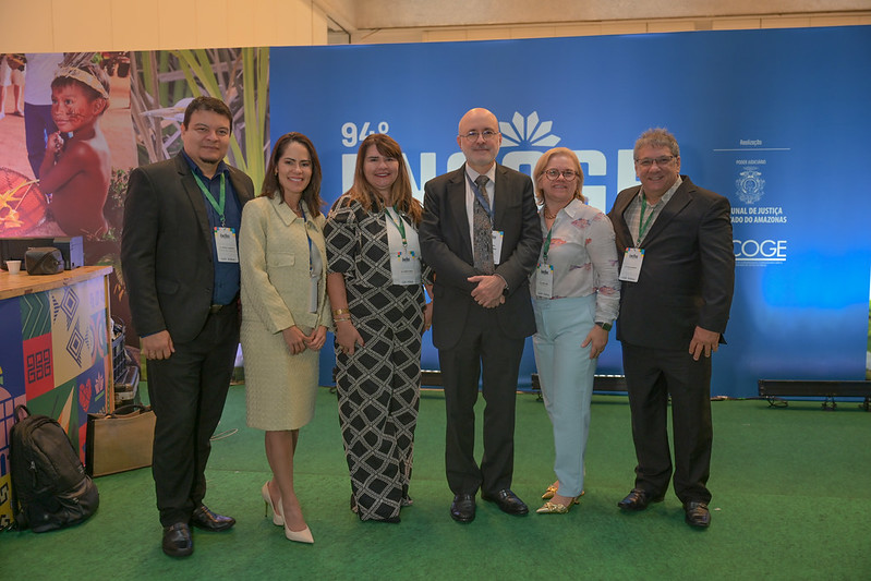 Seis pessoas em pé, incluindo o corregedor-geral Bandeira, as juízas Hélia e Roberta, os pesquisadores Silvio e Sara e o coordenador Samuel do Ministério das Cidades