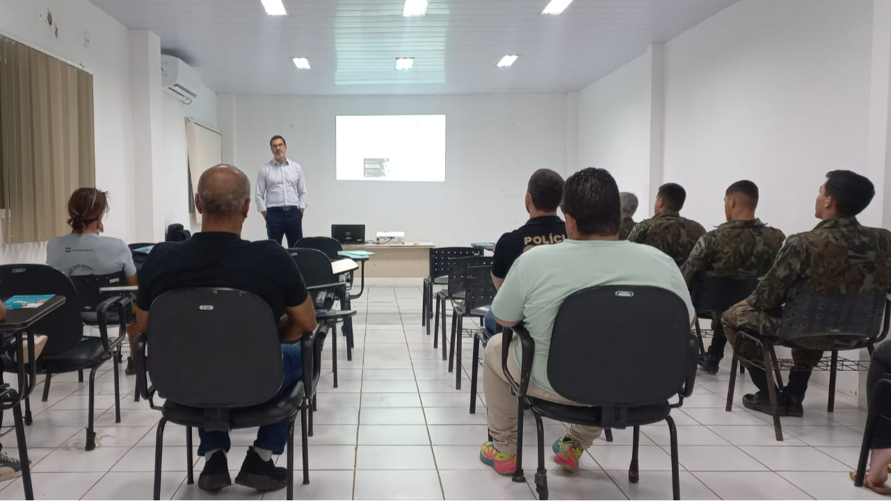 O juiz Rafael Moraes palestrando em uma sala com cerca de dez pessoas.